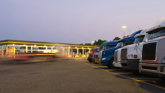 Evening truck stop lights of number of trucks in parking