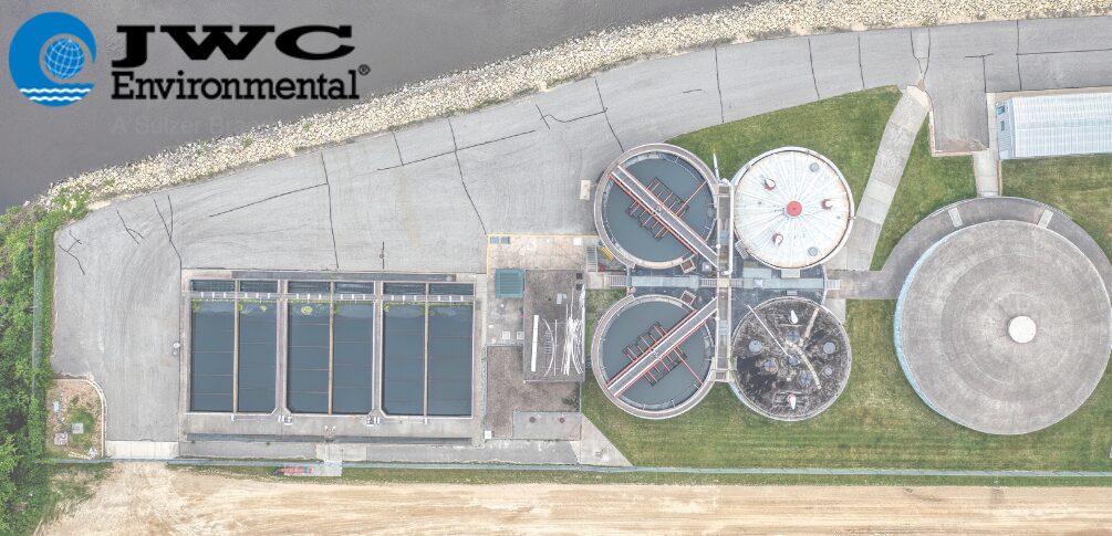 An aerial view of a wastewater processing facility. JWC Environmental's logo is overlayed in the top left corner.
