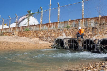 An inspector evaluates the flow of water